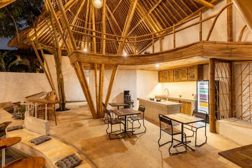 a large kitchen with wooden ceilings and tables and chairs at Clan Living - The Founder Ubud in Ubud