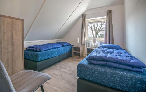 een slaapkamer met 2 bedden, een stoel en een raam bij Gorgeous Home In Den Ham With Sauna in Den Ham