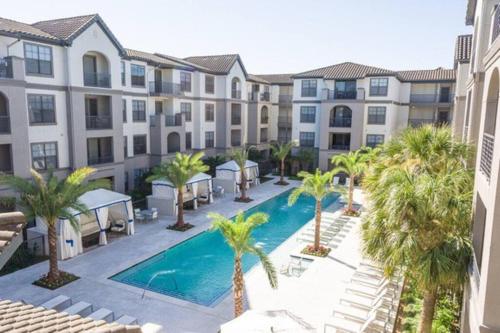 an apartment complex with a swimming pool and palm trees at Tropical Paradise- 2Bedroom/2Bath/NRG/MedCenter/Galleria in Houston
