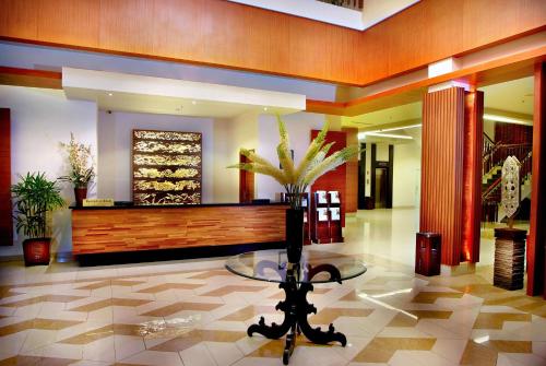 a lobby with a glass table in a building at Aston Tanjung City Hotel in Tanjung