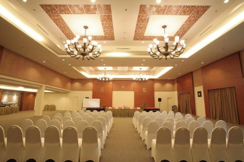 a conference room with white chairs and a podium at Aston Tanjung City Hotel in Tanjung
