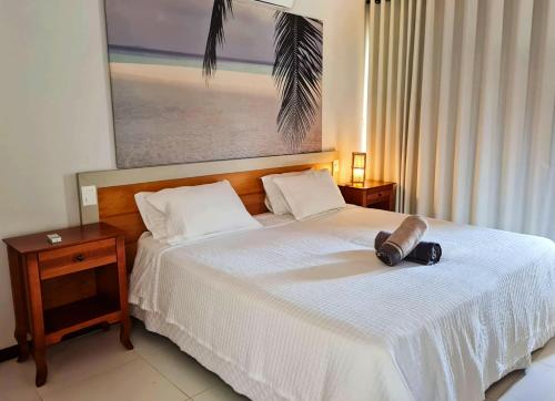 1 dormitorio con 1 cama grande con colcha blanca en Villa Bora Bora - Frente mar, Praia do Forte, en Praia do Forte