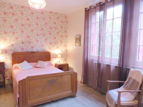 een slaapkamer met een bed en een stoel erin bij Gîte Hérisson, 3 pièces, 5 personnes - FR-1-489-15 in Hérisson