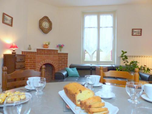 - un salon avec une table et un pain dans l'établissement Maison indépendante près du village médiéval avec jardin clos, parking et équipements complets - FR-1-489-15, à Hérisson