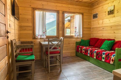 una habitación con un banco y una mesa en una cabaña en Drvene kuće ŠUŠKA, en Zaovine