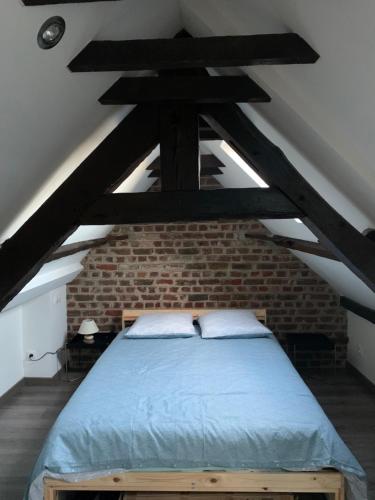 a bedroom with a bed in a brick wall at Voltaire 7 hyper-centre in Saint-Quentin
