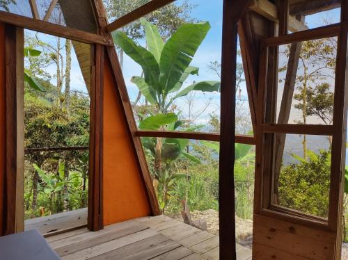 an open window in a room with a view of the forest at Monte La MaMa Ecolodge in Viotá