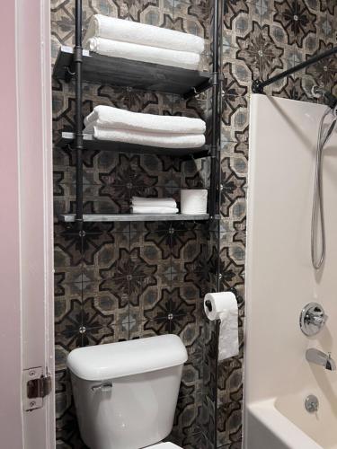 a bathroom with a toilet and towels on a wall at Rosewood Garden in Wisconsin Dells