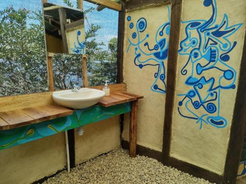 a bathroom with a sink and a painting on the wall at Monte La MaMa Ecolodge in Viotá