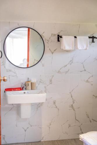 a white bathroom with a mirror and a sink at HR Resort in Ban Dong Bang