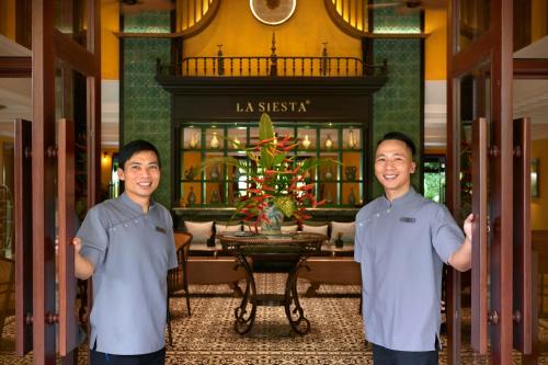 two men standing in the lobby of a hotel at La Siesta Hoi An Resort & Spa in Hoi An