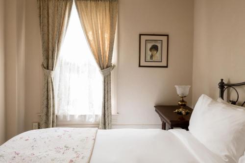 a bedroom with a white bed and a window at The Bishop Hotel in Port Townsend