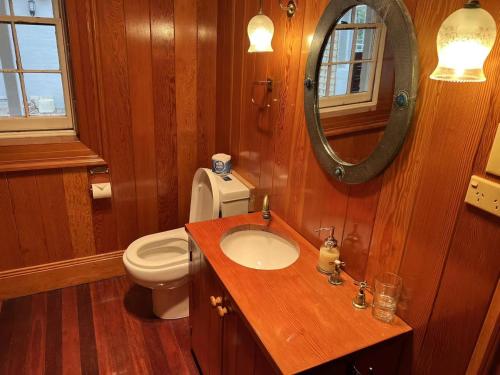 bagno con servizi igienici, lavandino e specchio di Eling Forest Winery a Sutton Forest
