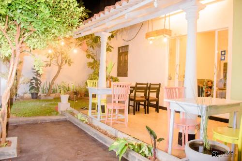 a patio with a table and chairs in a house at Blooming polhena in Matara