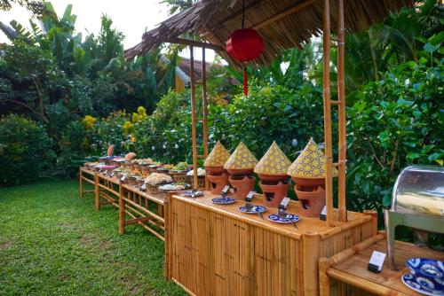 a long table with bowls and plates of food at La Siesta Hoi An Resort & Spa in Hoi An