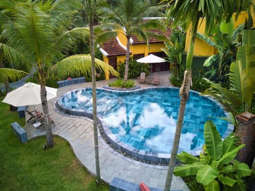 an overhead view of a swimming pool with palm trees at La Siesta Hoi An Resort & Spa in Hoi An