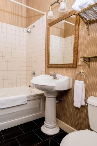 a bathroom with a sink and a tub and a toilet at The Bishop Hotel in Port Townsend