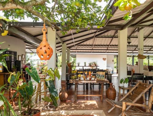 uma sala de jantar com mesa, cadeiras e árvores em Hotel Campestre El Triunfo em San Agustín