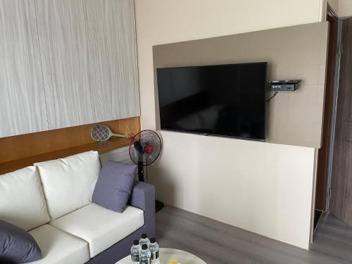 a living room with a white couch and a flat screen tv at Eli House in Toucheng