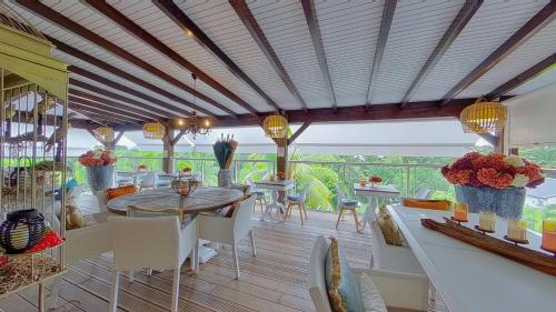 a dining room with a table and chairs at GREEN LORD DOMAINE - Lodges Piscine & Spa - Bar & Lounge - Restaurant gastronomique in Lamentin