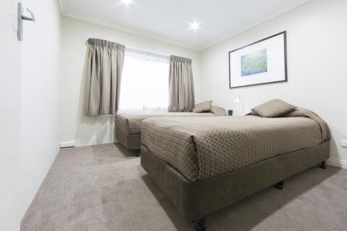 a bedroom with two beds and a window at Forrest Hotel & Apartments in Canberra