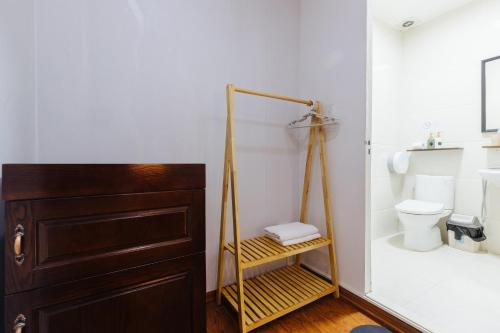 a bathroom with a toilet and a wooden cabinet at Legume House - 30m to centre in Hanoi