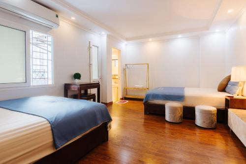 a bedroom with two beds and a desk and a window at Legume House - 30m to centre in Hanoi