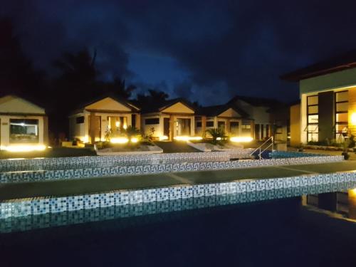 a villa with a swimming pool at night at Goichi Resort in Dipaculao
