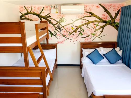 1 dormitorio con 2 literas y un mural de árboles en Goichi Resort, en Dipaculao