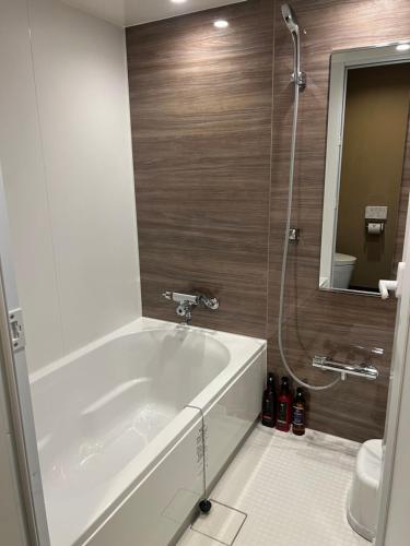 bagno con vasca e doccia con specchio di HOTEL GrayⅡ ad Osaka