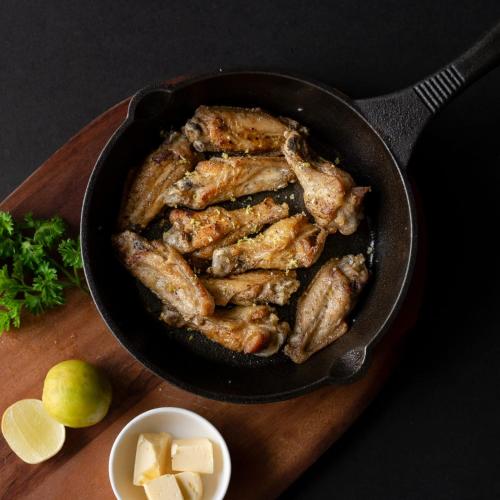 a pan filled with chicken and cheese and a bowl of cheese and lime at Niyati - Boutique Stay in Cochin