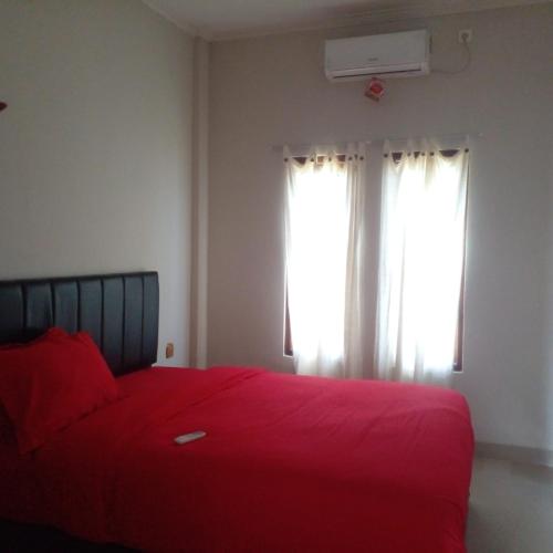 ラブハン・バジョにあるLembunai Home Stayのベッドルーム1室(赤いベッド1台、窓付)
