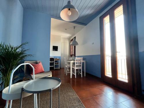 sala de estar con paredes azules, mesa y sillas en 2-bedroom flat in the heart of Bergamo city centre, en Bérgamo