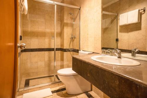 ein Bad mit einem WC, einem Waschbecken und einer Dusche in der Unterkunft Olympic Hotel in Jakarta