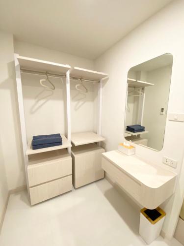 a white bathroom with a sink and a mirror at Mangkon Hostel in Bangkok