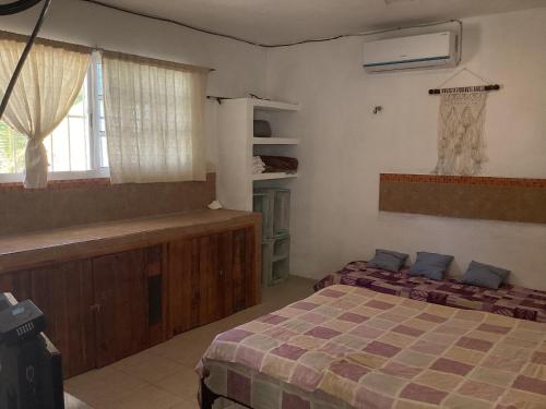 a bedroom with two beds and a window at Casa yuya in Chicxulub