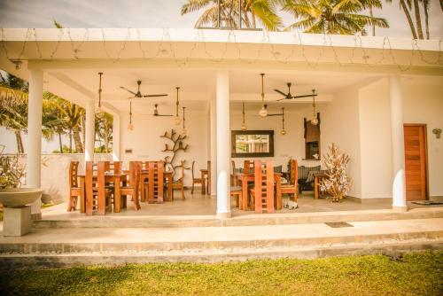 un patio con mesa y sillas. en Infinity of Sri Lanka en Paiyagala South