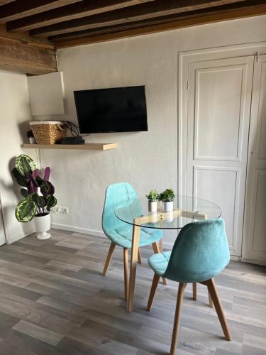 a dining room with a glass table and two chairs at Le cocoon Nuits in Nuits-Saint-Georges