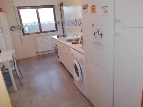 uma cozinha com um frigorífico branco e um lavatório em Apartamento El Prado em Almazán
