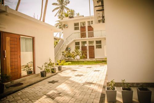 a courtyard with potted plants in front of a building at Infinity of Sri Lanka in Paiyagala South
