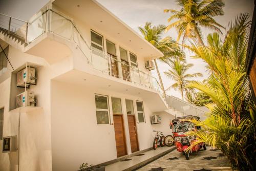a white house with a palm tree in front of it at Infinity of Sri Lanka in Paiyagala South