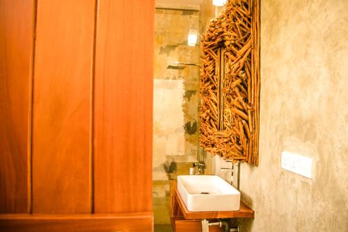 a bathroom with a sink and a mirror on the wall at Infinity of Sri Lanka in Paiyagala South