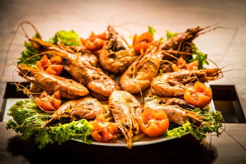 a plate of food with seafood and vegetables on a table at Infinity of Sri Lanka in Paiyagala South