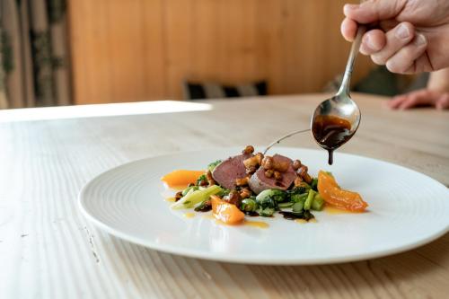 a person eating a plate of food with a spoon at Schlegelhof in Kirchzarten