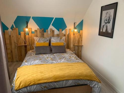 um quarto com uma cama com uma cabeceira de madeira em la parisienne ( 4 km de rouen ) em Le Mesnil-Esnard