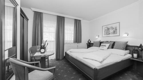 Hotel24Steps في ايشجل: غرفة نوم بسرير وطاولة وكرسي
