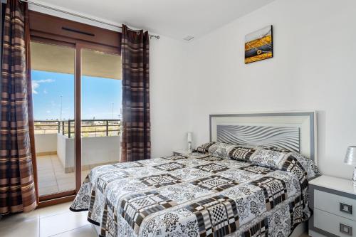 ein Schlafzimmer mit einem Bett und einem Balkon in der Unterkunft CB Living - Modern apartment, Terrazas de Campoamor in Orihuela