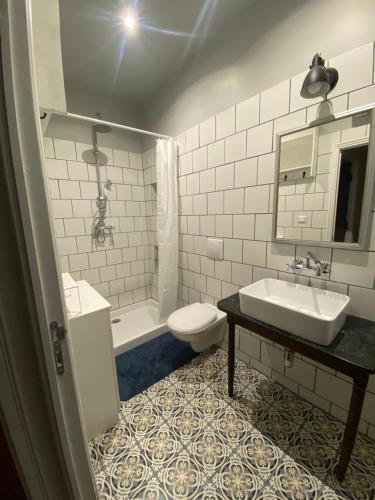 une salle de bain blanche avec un lavabo et des toilettes dans l'établissement Maison médiévale Albigeoise en centre ville, à Albi