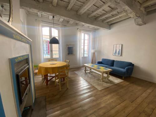 un salon avec un canapé bleu et une table dans l'établissement Maison médiévale Albigeoise en centre ville, à Albi