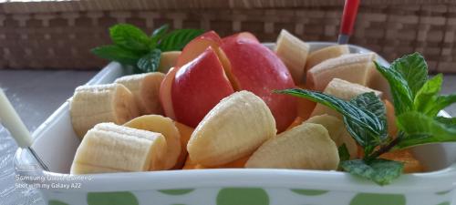 a bowl of fruit with apples and greens in it at Résidence Véronia in Rodrigues Island